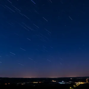 Starry night sky over Charleston with meteor streaks.